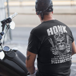 Man on a motorcycle wearing a funny sarcastic t-shirt honk if you want to see guns fired from a motorcycle featuring a skull and handguns