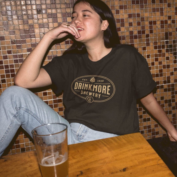 Woman wearing funny DrinkMore Brewery t-shirt with a beer from Shirty Store